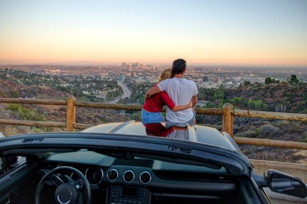 zonsondergang-los-angeles-californië Paar kijken naar de populaire zonsondergang in Los Angeles, Californië, zittend op de cabrioletkap.
